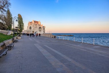 Okyanus ve gezinti güvertesi olan tarihi kumarhane binasının sahil manzarası. 3 Mayıs 2025 Romanya.