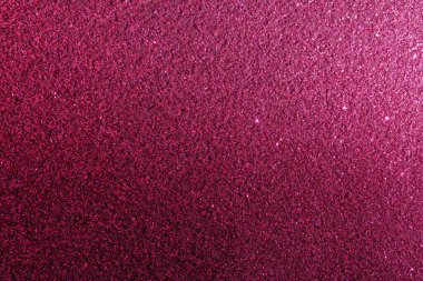 Pembe arka planda parıltılı bir yakın plan. Parıltı çeşitli boyutlarda ve arka planda dağınık. Bu görüntünün hayali, ruhani bir kalitesi var.