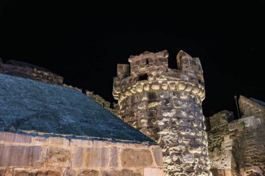 Ortaçağ kale kulesi yıldızlı gökyüzüne karşı gece aydınlandı.