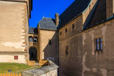 Taş duvarları ve mavi gökyüzü olan ortaçağ şatosu avlusu.