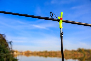 Açık mavi gökyüzüne karşı olta tutan olta kamışı.