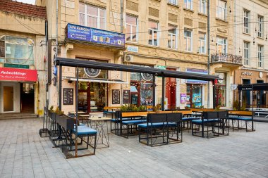 Avrupa şehir meydanında tarihi binaları olan açık bir kafe. 3 Mart 2026, Suceava Romanya.