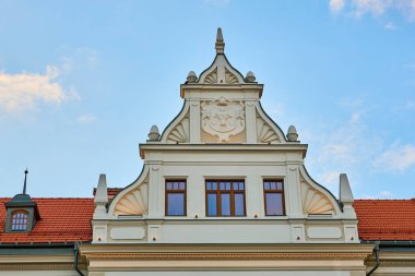 Dekoratif gable ve kırmızı çatılı tarihi Avrupa binası cephesi. 3 Mart 2026, Suceava Romanya.