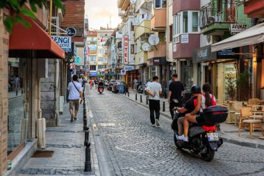 Cobblestone yolunda insanlarla ve motorsikletle dolu bir Avrupa caddesi. 2 Ağustos 2025, Canakkale Türkiye.