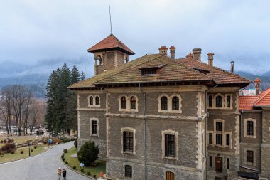 Kırmızı çatılı büyük bir bina, Cantacuzino Kalesi. 15 Aralık 2024 Busteni Romanya.