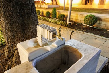 Dışarıdaki mermer çeşmeyi süsleyin. Pirinçten musluk da geceleri ağacın yanında olsun..