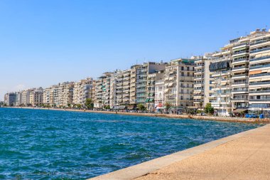 Arka planda bir şehir olan güzel mavi bir okyanus. Su sakin ve gökyüzü berrak. 8 Ağustos 2024 Selanik Yunanistan