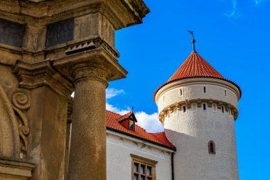 Kırmızı çatılı ve mavi gökyüzü arka planlı ortaçağ kale kulesi. 17 Mart 2025, Konopiste Şatosu, Çek Cumhuriyeti.