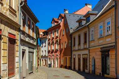 Huzurlu Avrupa kasabasında renkli tarihi binaları olan büyüleyici bir kaldırım taşı caddesi. 18 Mart 2025, Madalyon, Çek Cumhuriyeti.