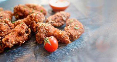 Susamlı fırında tavuk kanadı. Ketçap ve acı sos. Metin için boş alan. Ahşap arka plan. Lezzetli kızarmış tavuk kanatları..