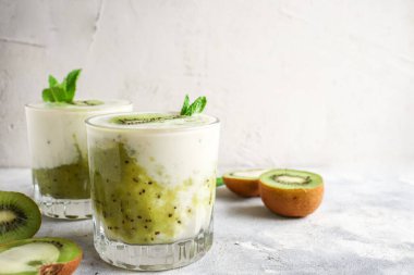Bardakta kivi ve yoğurt. Meyve ve meyve püresi. Kivi ve muzlu milkshake. Sağlıklı beslenme. Hafif arkaplan. Uzayı kopyala Vejetaryen yemeği
