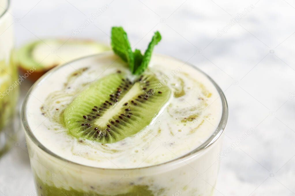 Yogurt with kiwi in a glass. Fruit and berry smoothie. Milkshake with kiwi and banana. Healthy eating. Light background. Copy space.