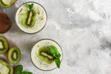 Bardakta kivi ve yoğurt. Meyve ve meyve püresi. Kivi ve muzlu milkshake. Sağlıklı beslenme. Hafif arkaplan. Uzayı kopyala Üst görünüm