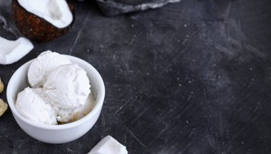 Hindistan cevizli vejetaryen dondurması, beyaz bardakta. Dondurma topları. Koyu arkaplan, alanı kopyala.