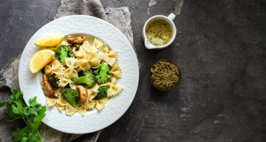 Brokoli, tavuk ve fesleğenli Farfalle. İtalyan yemeği. Üst Manzara. Ahşap arka plan. Boşluğu kopyala.