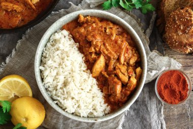 Geleneksel köri ve malzemeler. Tikka Masala tavuk ve pilav. Hint yemeği. Üst Manzara. Uzayı kopyala Ahşap arkaplan.