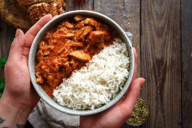 Geleneksel köri ve malzemeler. Tikka Masala tavuk ve pilav. Hint yemeği. Üst Manzara. Uzayı kopyala Ahşap arka plan. El ve yemek.
