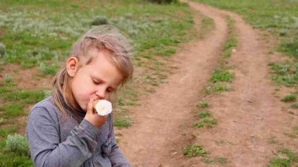 Jente 4 år gammel spiser glad is på en vårdag. Et barns glede. Barne og iskrem. – stockvideo