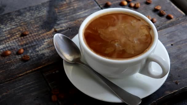 Kaffeetasse vorhanden. Milch wird in eine Tasse Kaffee gegossen. Zeitlupe. — Stockvideo