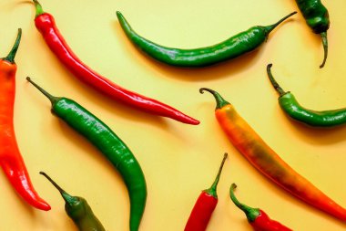 Sarı arka planda çok renkli kırmızı biber, fotokopi alanı ile yaratıcı minimalizm kavramı. Üst görünüm