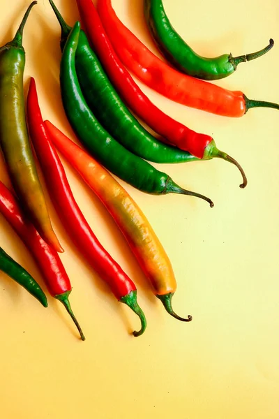 Sarı arka planda çok renkli kırmızı biber, fotokopi alanı ile yaratıcı minimalizm kavramı. Üst görünüm
