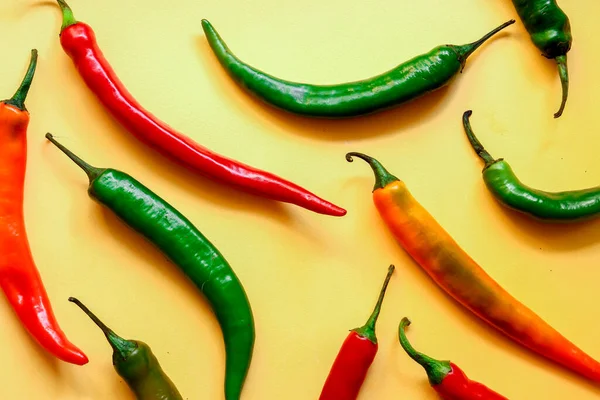 Sarı arka planda çok renkli kırmızı biber, fotokopi alanı ile yaratıcı minimalizm kavramı. Üst görünüm