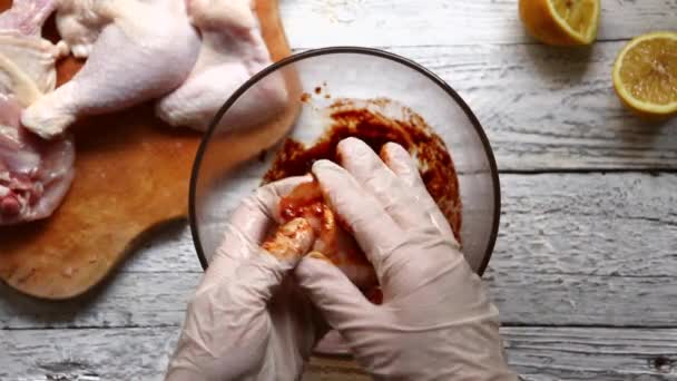 A woman marinates meat for a barbecue. The chef marinates chicken wings. Top view. Cooking in the kitchen. — Stok video