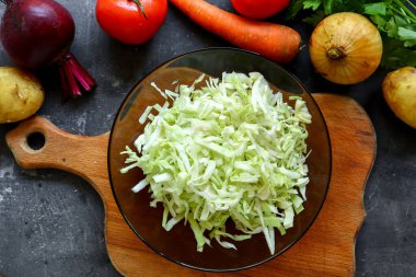 Adım adım sebze çorbası ya da sebze çorbası pişiriyorum. Lahana dilimliyorum. Malzemeler. Üst görünüm.