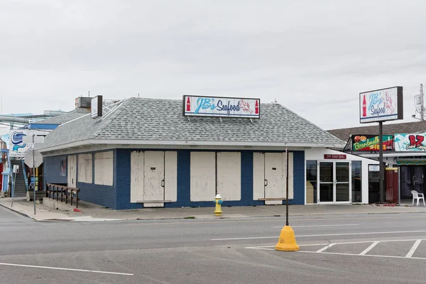 A classic New England seafood restaurant stands empty on the boardwalk because of COVID-19 restrictions at Hampton Beach, New Hampshire. A normally packed tourist destination is now mostly desolate other than beach walkers and locals. — Stock Image Classic New England Seafood Restaurant Stands Empty Boardwalk Because Covid Royalty Free Stock Photos