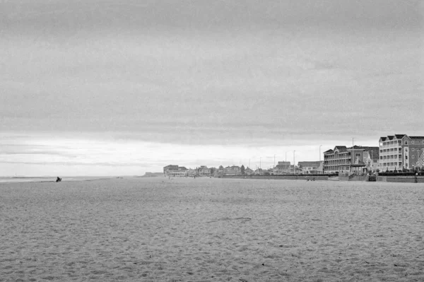 オフシーズンのローセットビューハンプトンビーチの海と曇りの日に砂 海岸を下っていくと 霧の中で消えていくイメージの右側にボードウォークが見えます 画像はアナログ白黒フィルムで撮影されました — ストック写真