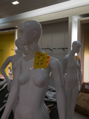 Mağazanın kapanış satışı sırasında üzerine fiyat etiketleri iliştirilmiş mankenler sergileniyor. Tüm eşyalar satılıktır..