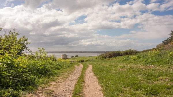İrlanda 'nın doğu kıyısındaki Red Rock, Sutton, Dublin İlçesi' nde yürüyüş yolu. Martello Kulesi ve Dublin Körfezi uzaktan görülebilir..