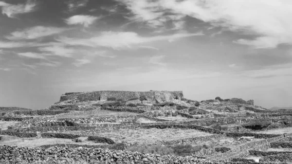 İrlanda 'nın batı kıyısındaki Aran Adaları' ndan biri olan Inishmaan 'daki engebeli taştan manzaranın ve karakteristik kuru taş duvarların siyah ve beyaz görüntüsü..