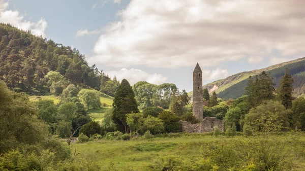 Glendalough, Co. Wicklow, İrlanda 'daki Round Tower ve Woodland. Glendalough Vadisi Wicklow Dağları Ulusal Parkı 'nda yer almaktadır..