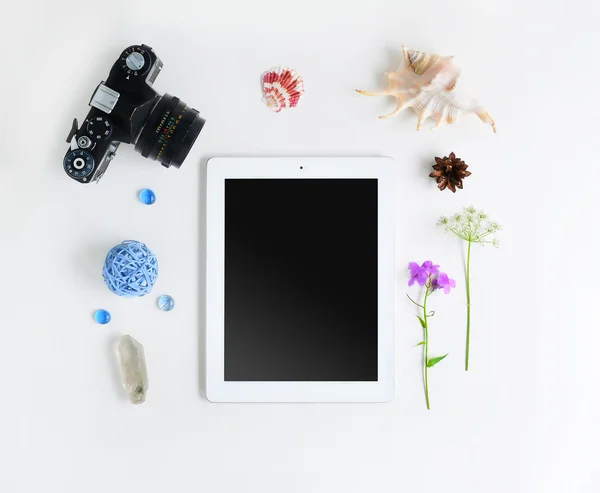 Tablet, kamera, çiçekler ve kabukları