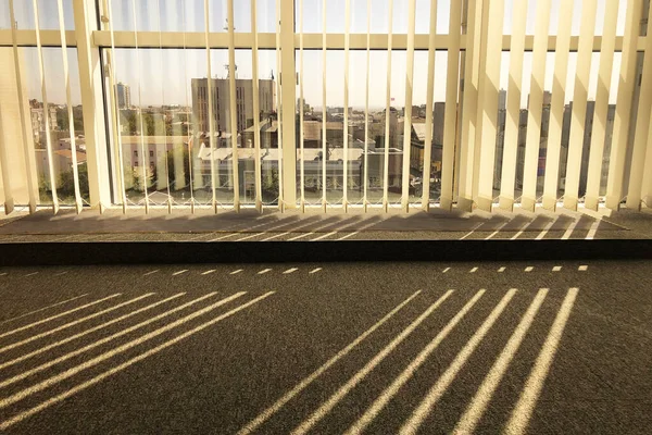 sunlight is shining through office window with jalousie on it, Stripped pattern of light and shadows on office carpet floor. Morning mood in office, getting ready for work.