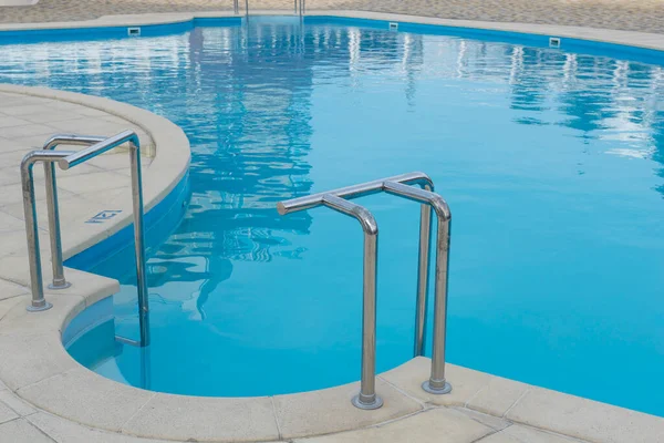 蓝水游泳池的金属游泳池梯子扶手 周围没有人 — 图库照片