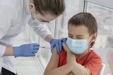 Gözleri kapalı çocuk enjeksiyondan çok korkuyor, doktor elinde şırınga ve aşı yapılmış çocuk, virüse karşı koruyucu önlemler, aşı konsepti