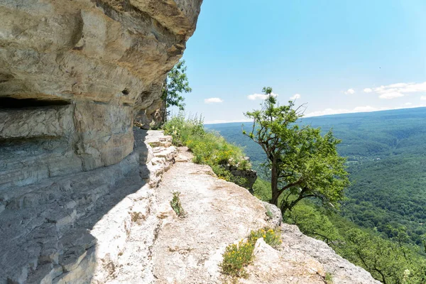 Footpath on rock in high green mountains, Eagle shelf in Caucasus. Hiking in beautiful places, healthy lifestyle.