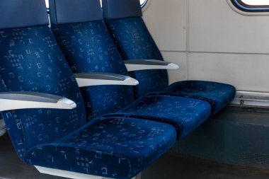 Mavi koltukları boş trende üç sıra halinde kapatın, vagonda kimse yok, rahat ulaşım yolu, seyahat konsepti