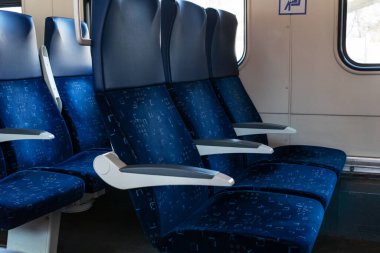 Mavi koltukları boş trende üç sıra halinde kapatın, vagonda kimse yok, rahat ulaşım yolu, seyahat konsepti