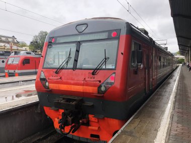 Tren istasyonundaki kırmızı trenin görüntüsü kalkışa hazır. Seyahat ve ulaşım kavramı.