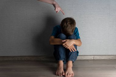 Tacize uğramış çocuk yüzünü dizlerinin arasına saklıyordu. Yetişkin eli parmağıyla başının üstündeydi. Ev şiddeti ve ceza