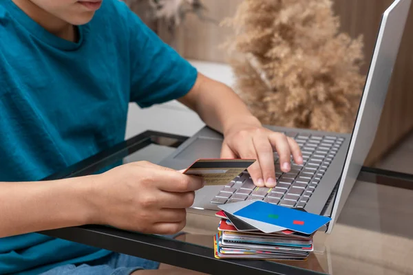 Çocuğun ellerini kredi kartıyla ve bilgisayarın yanında online ödeme yapan bir yığın farklı kartla kapat. Yeni gerçeklik, evden online alışveriş kolaylığı