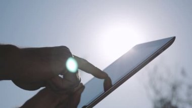 Arka plan gökyüzü üzerinde IPAD bilgisayar kullanarak ele