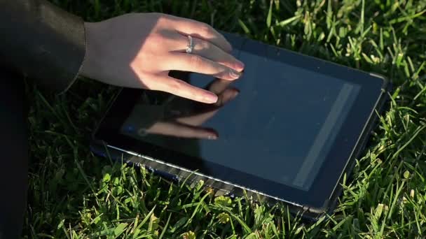 Fille abstraite en utilisant une tablette sur une herbe — Video