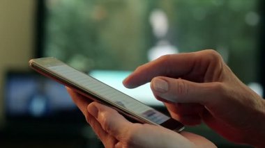 Bir akıllı telefon evde Tv ve arka plan kullanarak bir el closeup
