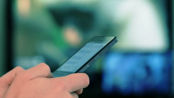 Mensajes de texto de mano masculina en el teléfono inteligente en casa — Vídeo de stock