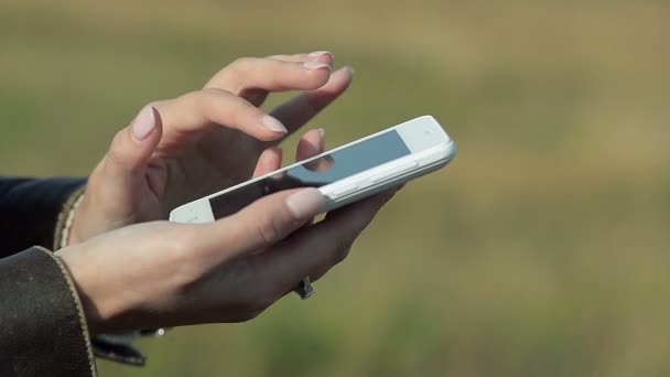 Kobieta pisze wiadomość na telefon na zewnątrz z bliska — Wideo stockowe