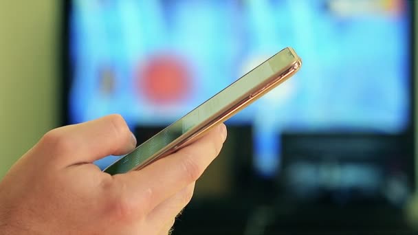 Homme écriture à la main SMS sur Smartphone à la maison 